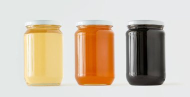 Farklı tipte kavanozlar ve beyaz arka planda izole edilmiş çiğ bal renkleri. Arıcılık ürünleri kavramı, alternatif terapi ya da doğal sağlıklı yiyecekler. Minimalizm.