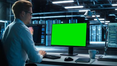 Veri Merkezi: Bir Gözetleme Ofisinde Yeşil Ekran Modeli olan Erkek Ofis İşçisi Bilgisayarı Kullanıyor. Uzman Krom Anahtar Ekranı Önünde Çalışıyor.