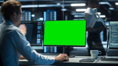 Profosyonel Bilişim Teknik Destek Uzmanı ve Yazılım Geliştirme Geliştiricisi, Yeşil Ekran Görünümü ile Dijital Ekranlarla İzleme Odasında Çalışıyor.