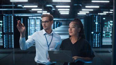 Fabrika Ofisi: Kadın mühendis dizüstü bilgisayarı elinde tutuyor, uzağa bakıyor ve Erkek Proje Müdürü ile beyin fırtınası yapıyor. Modern Endüstri Araştırma ve Geliştirme Merkezi.