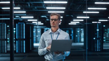 Kafkas Genç Bilgi İşlem Uzmanı Laptop kullanıyor, Veri Merkezi 'nde duruyor. Yetenekli Adam Web Hizmetleri 'nde çalışıyor. Bulut Hesaplama, Sunucu Analitiği, Siber Güvenlik Bakımı