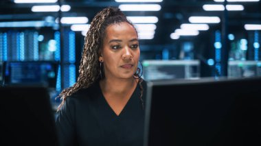 Ofis ortamında bilgisayar üzerinde çalışan odaklanmış bir bilişim uzmanı. Çeşitli Çoklu Etnik Kadın Geliştirici Gece Geç saatlerde Kod Yazarken İki Monitör Kullanıyor