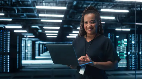ブラック女性チーフテクノロジーオフィス ラップトップコンピュータを使用して ビッグオフィスデータセンターに立っています Saas クラウドWebサービスで作業するシステム管理者 Eビジネスデジタル起業家コンセプト — ストック写真