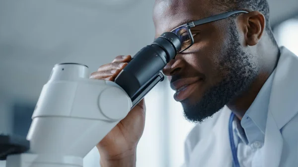 Yakışıklı Siyah Bir Bilim Adamının Gözlük Takan Mikroskopa Bakan Makro — Stok fotoğraf
