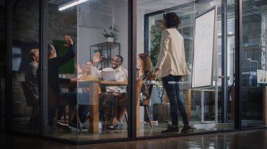 Proje Müdürü Ajans 'taki Toplantı Odası' nda Genç Yaratıcı Ekip için Sunum Yapıyor. Meslektaşlar Konferans Masasının Arkasında Oturur İş Geliştirme, Kullanıcı Arayüzü ve Tasarım.