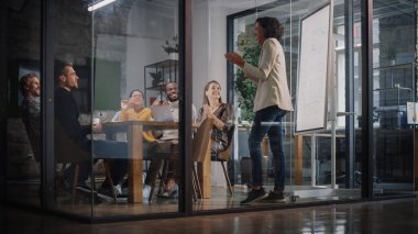 Proje Müdürü Ajans 'taki Toplantı Odası' nda Genç Yaratıcı Ekip için Sunum Yapıyor. Meslektaşlar Konferans Masasının Arkasında Oturur İş Geliştirme, Kullanıcı Arayüzü ve Tasarım.