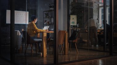 Genç Latin Pazarlama Uzmanı Gözlüklü Kısa Saçlı Yoğun Yaratıcı Ofis Ortamı 'nda Dizüstü bilgisayar üzerinde çalışıyor. Çok Irklı Çok Irklı Güzel Proje Yöneticisi Sunum Yapıyor.