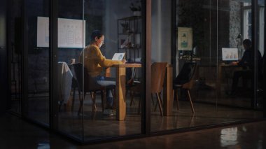 Genç Latin Pazarlama Uzmanı Gözlüklü Kısa Saçlı Yoğun Yaratıcı Ofis Ortamı 'nda Dizüstü bilgisayar üzerinde çalışıyor. Çok Irklı Çok Irklı Güzel Proje Yöneticisi Sunum Yapıyor.