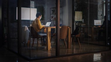 Genç Latin Pazarlama Uzmanı Gözlüklü Kısa Saçlı Yoğun Yaratıcı Ofis Ortamı 'nda Dizüstü bilgisayar üzerinde çalışıyor. Çok Irklı Çok Irklı Güzel Proje Yöneticisi Sunum Yapıyor.