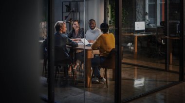 Genç Yaratıcı Ekip İş Ortakları ile Teşkilat 'taki Cam Duvarlar Arkasındaki Konferans Odası' nda Görüşüyor. Meslektaşlar Konferans Masasının Arkasında Oturur ve İş Fırsatları, Büyüme ve Geliştirme.