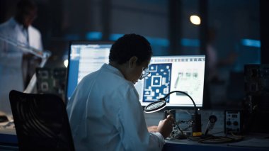 Modern Elektronik Araştırma, Geliştirme Tesisi: Kara Kadın Mühendis Bilgisayar Anakart Lehim Yapıyor. Bilim adamları PCB, Silikon Mikroçipler, Yarı iletkenler tasarlıyor. Arka Görünüm Görüntüsü