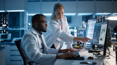 Elektronik Araştırma, Geliştirme Tesisi: Bilgisayar üzerinde çalışan Baş Mühendis ile Kadın Mühendis Proje Yöneticisi Görüşmeleri. IT Geliştiriciler Ekibi Silikon Mikroçip, Yarı iletken, PCB Tasarımı Çalışıyor