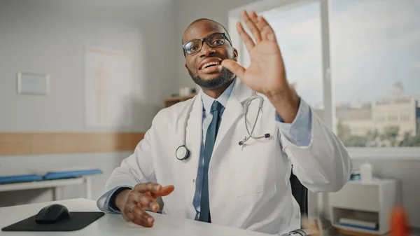 Doctor\'s Online POV Medical Consultation: African American Physician is Making a Video Call with a Patient. Black Health Care Professional Giving Advice, Making Greeting Gesture. Point of View Shot