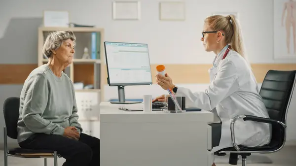 Female Family Doctor Prescribing Treatment Senior Patient Speaking Her Consultation — Stock Photo, Image
