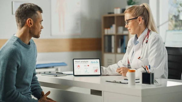 Kvinnlig Läkare Visar Hjärtanalysresultat Tablettdator Till Ung Manlig Patient Konsultation — Stockfoto