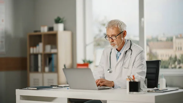 Ofisinde Dizüstü Bilgisayarla Çalışan Deneyimli Orta Yaşlı Erkek Bir Doktorun — Stok fotoğraf