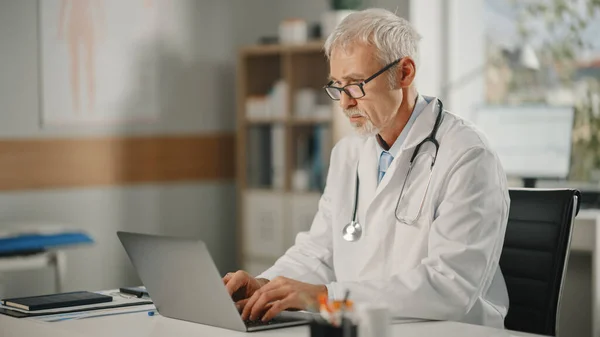 Ofisinde Dizüstü Bilgisayarla Çalışan Deneyimli Orta Yaşlı Erkek Bir Doktorun — Stok fotoğraf