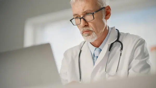 Erfahrener Arzt Mittleren Alters Weißen Kittel Der Seinem Büro Laptop — Stockfoto