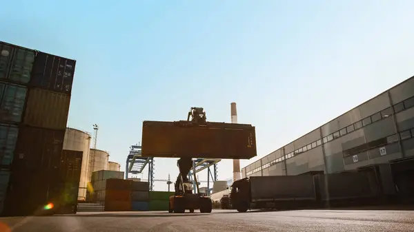 近代的なコンテナハンドラー造船所ターミナルで大きな赤い鋼の輸送貨物コンテナを運ぶ 取扱装置の運転者が物流センターにクレートを積み込んでいます — ストック写真