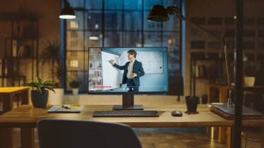 Tatlı Erkek Öğretmen Geometri Dersini Açıklayan Online Ders Veren Bir Masaüstü Bilgisayarının Çekimi. Modern Yaratıcılık Ofisi 'ndeki Ahşap Masa' nın üzerinde duruyor. Ilık Akşam Işığı