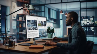 Yaratıcı Ev Oturma Odasında Masaüstü Bilgisayarı 'nda çalışan yakışıklı siyahi Amerikalı Uzman. Serbest Erkek Finansal Piyasa Analizi için Haberler Okumakta ve Müşteri ve İşveren Raporu.