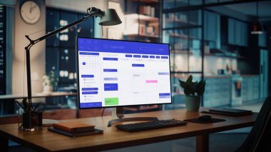 Yaratıcı Konforlu Oturma Odası 'ndaki Ahşap Masanın Üzerinde Açık Takvim Uygulaması ile Masaüstü Bilgisayarı Çekimi. Arkaplanda Gece Işığı ve Açık Uzay Stüdyosunda.