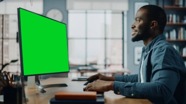 Masaüstü Bilgisayarı 'nda çalışan yakışıklı siyahi Amerikalı Uzman Ev Oturma Odası' nda Yeşil Ekran Moda Ekranı. Sosyal ağlarda Müşterilerle İnternet üzerinden Konuşan Serbest Adam.