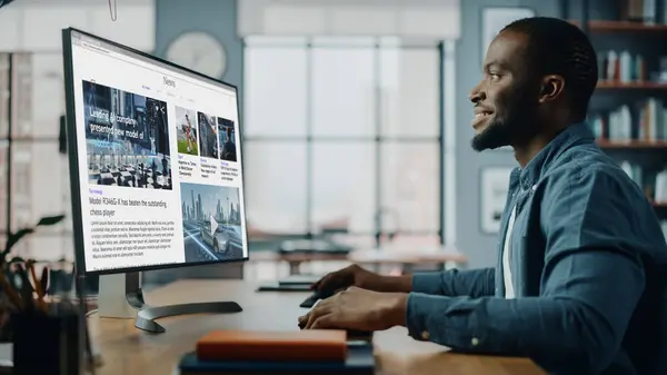 Yaratıcı Ev Oturma Odasında Masaüstü Bilgisayarı 'nda çalışan yakışıklı siyahi Amerikalı Uzman. Serbest Erkek Finansal Piyasa Analizi için Haberler Okumakta ve Müşteri ve İşveren Raporu.