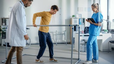 Hastane Fiziksel Terapi Odası: Paralel Barlar İçin Yaralı Yürüyen Hasta, Profesyonel Fizyoterapist ve Doktor Yardım, Eğitim Engelli Kişiler İçin Tedavi