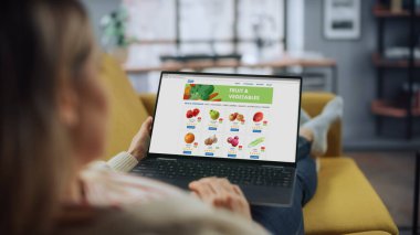 Güzel Beyaz Dişi, Taze Meyve ve Sebze Siparişi Vermek İçin Laptop Bilgisayar Kullanıyor. Ev Oturma Odası 'nda. Evden Çalışan Serbest Uzman İnternet Sörfü.