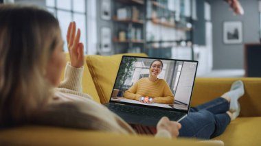 Ev Oturma Odası 'ndan dizüstü bilgisayarında Yakışıklı Kadın Arkadaşı ile Görüntülü Konuşan Genç Kadın. Ev Uzmanı 'ndan internet üzerinden müdürle telefon görüşmesi yapıyorum..