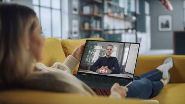 Ev Oturma Odası 'ndaki laptopta yakışıklı beyaz arkadaşıyla görüntülü bir telefon görüşmesi yapan genç bir bayan. Ev Uzmanı 'ndan internet üzerinden müdürle telefon görüşmesi yapıyorum..