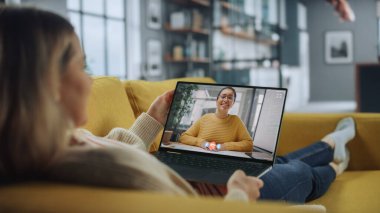 Ev Oturma Odası 'ndan dizüstü bilgisayarında Yakışıklı Kadın Arkadaşı ile Görüntülü Konuşan Genç Kadın. Ev Uzmanı 'ndan internet üzerinden müdürle telefon görüşmesi yapıyorum..