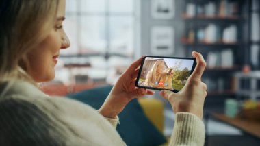 Ev Oturma Odası 'ndan Smartphone' da Güzel Arkadaşı ile Bir Köpekle Oynayan Bir Kadın Sohbetinin Kapanışı. Serbest Çalışan İnternetten Bir Müşteriyle Sohbet Ediyor.