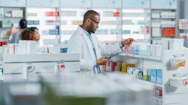 Eczane: Profesyonel Siyah Eczacının Portresi Dijital Tablet Bilgisayar kullanıyor, İlaç, İlaç, Vitamin, Sağlık Ürünleri Envanterini Kontrol Ediyor. Eczanedeki Eczacı.