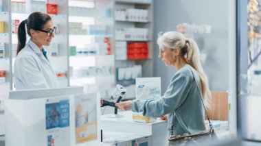 Eczane kasası: Profesyonel Kadın Eczacı Çeşitli Etnik Müşteriler Grubu 'na İlaç ve Vitamin satın almak için Kontaksız Kredi Kartı ile İlaç Satıyor