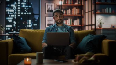 Evdeki Evdeki Gece ve Tablet Bilgisayarı 'nda, Rahat Karanlık Oturma Odasında, Koltukta Oturan Güzel Otantik Latin Kadın. İnterneti geziyor, Stylus Kalem 'le yazı ve çizim yapıyor..