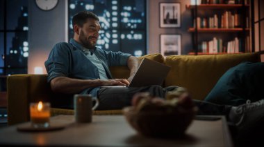 Evdeki Evdeki Gece ve Tablet Bilgisayarı 'nda, Rahat Karanlık Oturma Odasında, Koltukta Oturan Güzel Otantik Latin Kadın. İnterneti geziyor, Stylus Kalem 'le yazı ve çizim yapıyor..