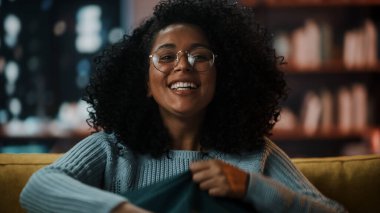 Evdeki Evdeki Gece ve Tablet Bilgisayarı 'nda, Rahat Karanlık Oturma Odasında, Koltukta Oturan Güzel Otantik Latin Kadın. İnterneti geziyor, Stylus Kalem 'le yazı ve çizim yapıyor..