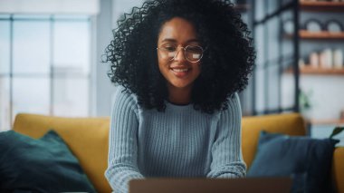 Evdeki Evdeki Gece ve Tablet Bilgisayarı 'nda, Rahat Karanlık Oturma Odasında, Koltukta Oturan Güzel Otantik Latin Kadın. İnterneti geziyor, Stylus Kalem 'le yazı ve çizim yapıyor..
