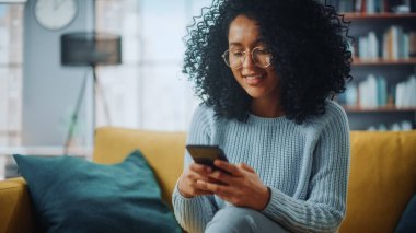 Evdeki Evdeki Gece ve Tablet Bilgisayarı 'nda, Rahat Karanlık Oturma Odasında, Koltukta Oturan Güzel Otantik Latin Kadın. İnterneti geziyor, Stylus Kalem 'le yazı ve çizim yapıyor..