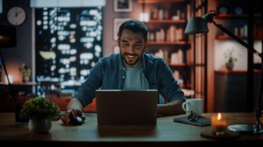 Evdeki Evdeki Gece ve Tablet Bilgisayarı 'nda, Rahat Karanlık Oturma Odasında, Koltukta Oturan Güzel Otantik Latin Kadın. İnterneti geziyor, Stylus Kalem 'le yazı ve çizim yapıyor..