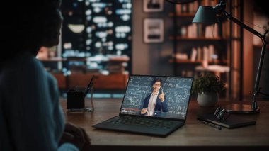 Evdeki Evdeki Gece ve Tablet Bilgisayarı 'nda, Rahat Karanlık Oturma Odasında, Koltukta Oturan Güzel Otantik Latin Kadın. İnterneti geziyor, Stylus Kalem 'le yazı ve çizim yapıyor..