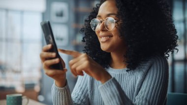 Evdeki Evdeki Gece ve Tablet Bilgisayarı 'nda, Rahat Karanlık Oturma Odasında, Koltukta Oturan Güzel Otantik Latin Kadın. İnterneti geziyor, Stylus Kalem 'le yazı ve çizim yapıyor..