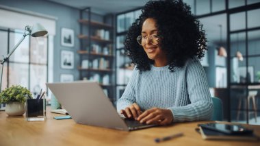 Evdeki Evdeki Gece ve Tablet Bilgisayarı 'nda, Rahat Karanlık Oturma Odasında, Koltukta Oturan Güzel Otantik Latin Kadın. İnterneti geziyor, Stylus Kalem 'le yazı ve çizim yapıyor..