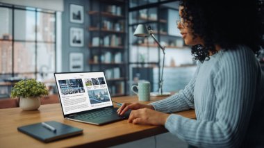 Evdeki Evdeki Gece ve Tablet Bilgisayarı 'nda, Rahat Karanlık Oturma Odasında, Koltukta Oturan Güzel Otantik Latin Kadın. İnterneti geziyor, Stylus Kalem 'le yazı ve çizim yapıyor..