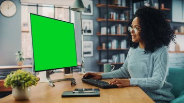 Evdeki Evdeki Gece ve Tablet Bilgisayarı 'nda, Rahat Karanlık Oturma Odasında, Koltukta Oturan Güzel Otantik Latin Kadın. İnterneti geziyor, Stylus Kalem 'le yazı ve çizim yapıyor..