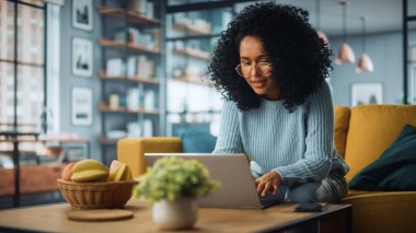 Evdeki Evdeki Gece ve Tablet Bilgisayarı 'nda, Rahat Karanlık Oturma Odasında, Koltukta Oturan Güzel Otantik Latin Kadın. İnterneti geziyor, Stylus Kalem 'le yazı ve çizim yapıyor..