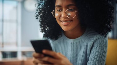 Evdeki Evdeki Gece ve Tablet Bilgisayarı 'nda, Rahat Karanlık Oturma Odasında, Koltukta Oturan Güzel Otantik Latin Kadın. İnterneti geziyor, Stylus Kalem 'le yazı ve çizim yapıyor..