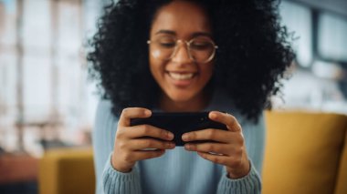 Evdeki Evdeki Gece ve Tablet Bilgisayarı 'nda, Rahat Karanlık Oturma Odasında, Koltukta Oturan Güzel Otantik Latin Kadın. İnterneti geziyor, Stylus Kalem 'le yazı ve çizim yapıyor..